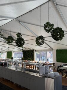 Växtinredning med hängande konstväxter och växtväggar i matsal med serveringsyta